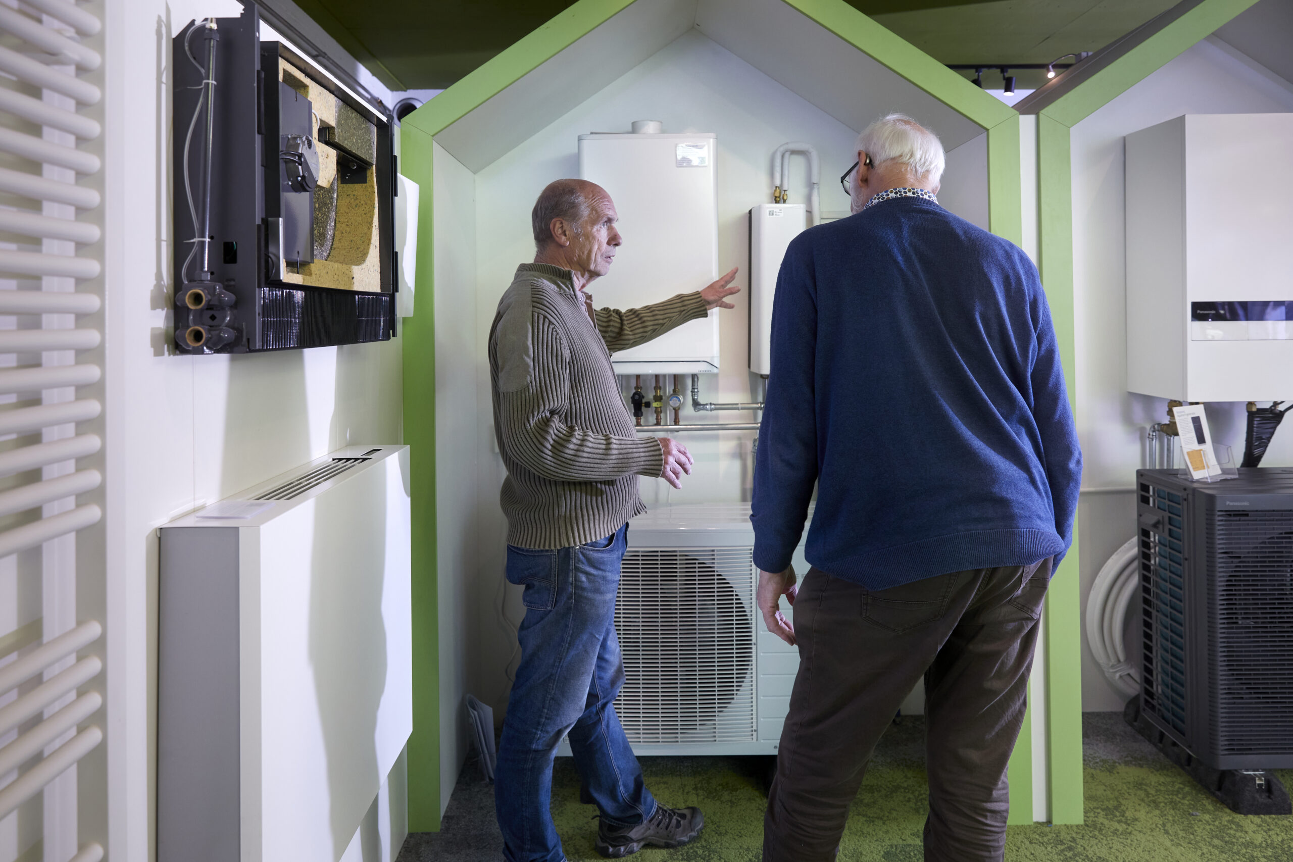 Medewerker (vrijwilliger) geeft bezoek Mijn Groene Huis in het Regionaal Energiecentrum uitleg over verschillende apparatuur.