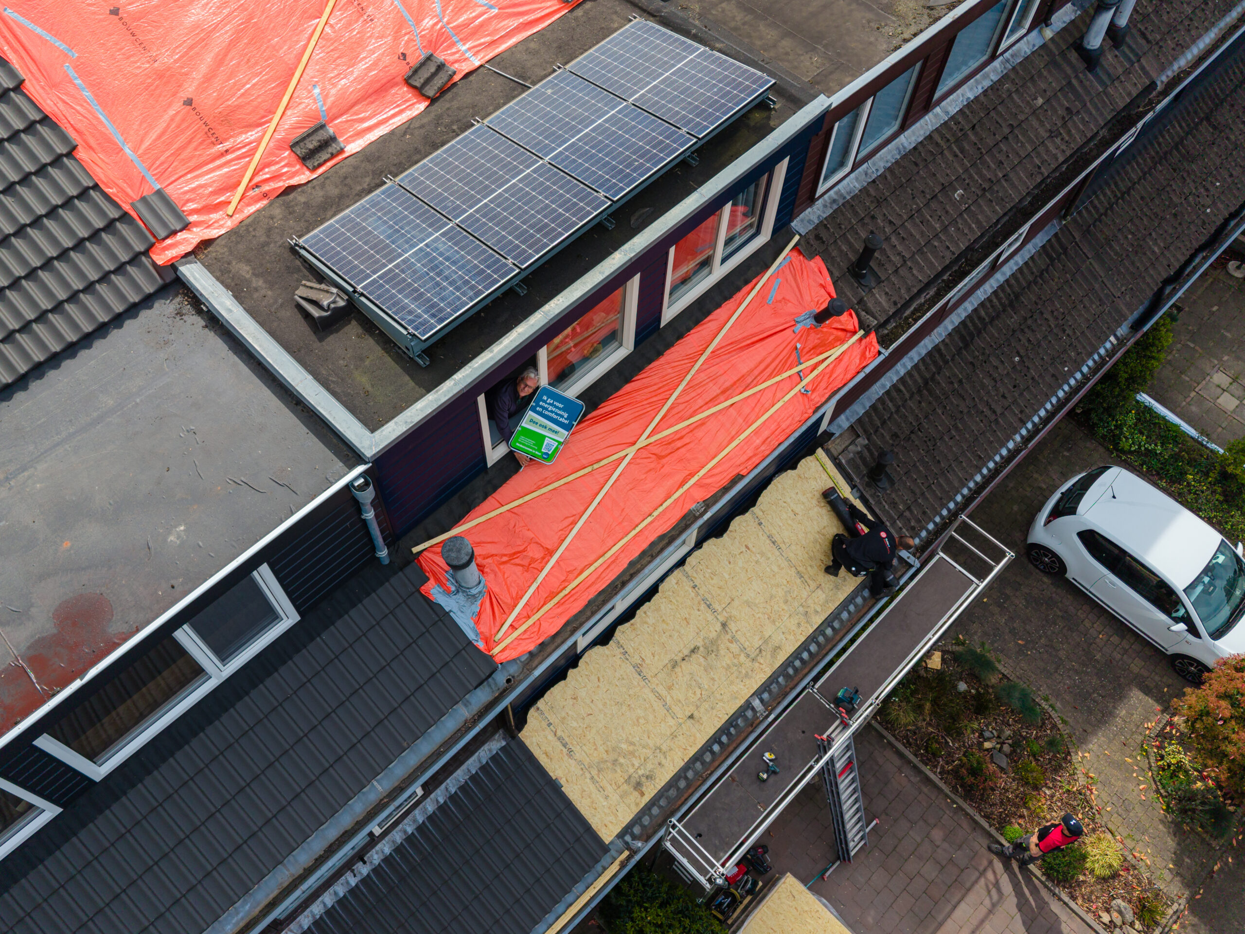 Bewoner bij woning in Zeist met verduurzamingsmaatregelen en campagnebord energiezuinig en comfortabel.